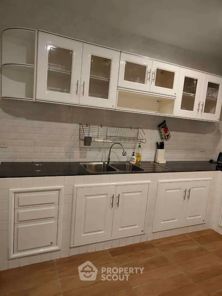 Modern kitchen with white cabinets and sleek black countertop