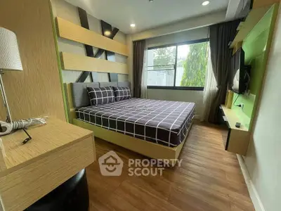 Modern bedroom with stylish decor and large window offering natural light.