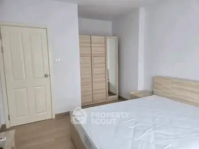Spacious bedroom with modern wooden furniture and ample natural light.