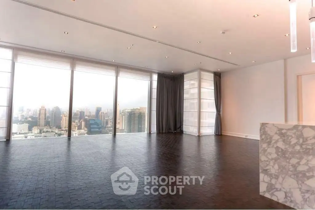 Spacious modern living room with panoramic city views and elegant marble accents.