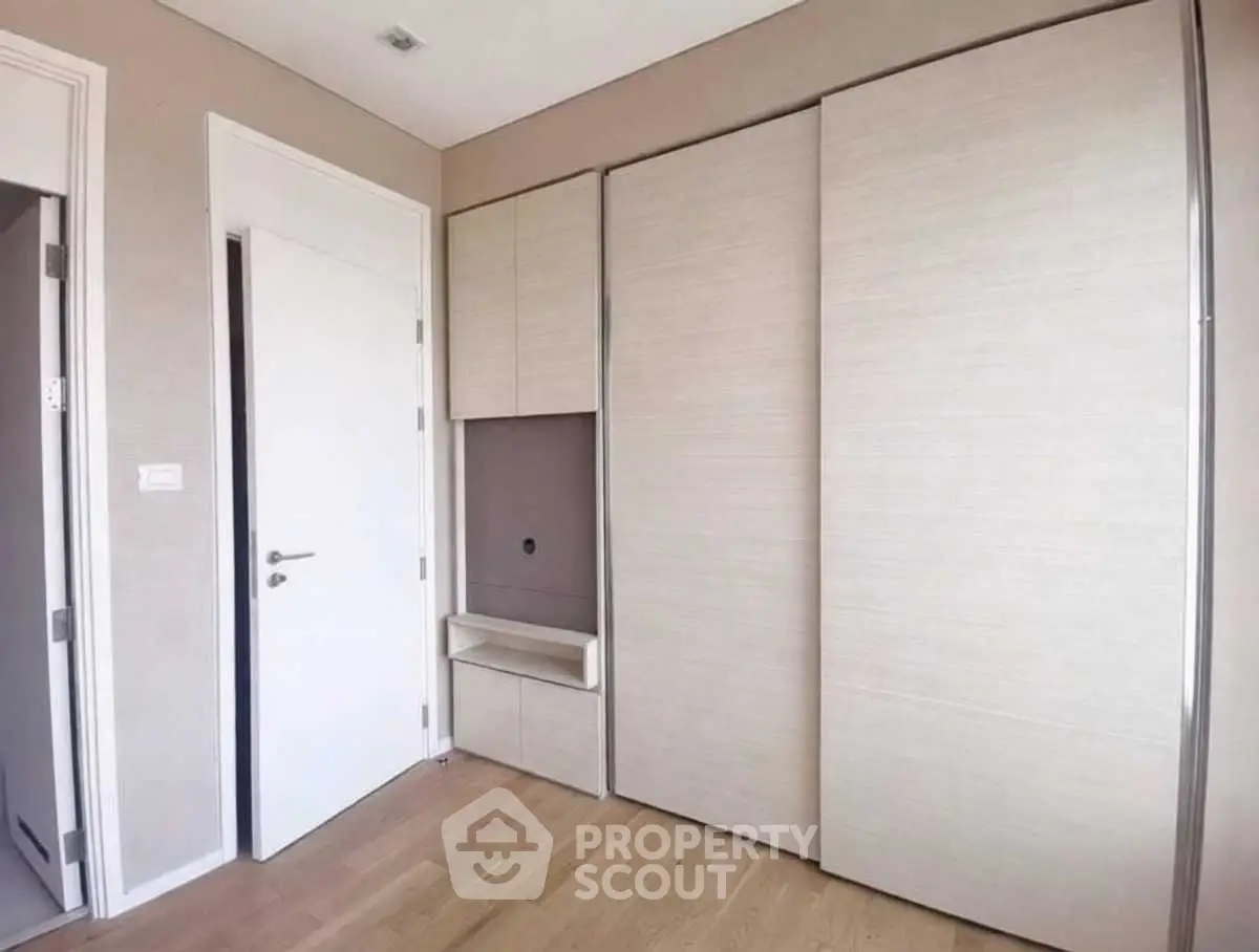 Modern minimalist bedroom with built-in wardrobe and wooden flooring