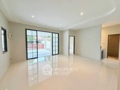 Spacious modern living room with large windows and glossy tiled floors