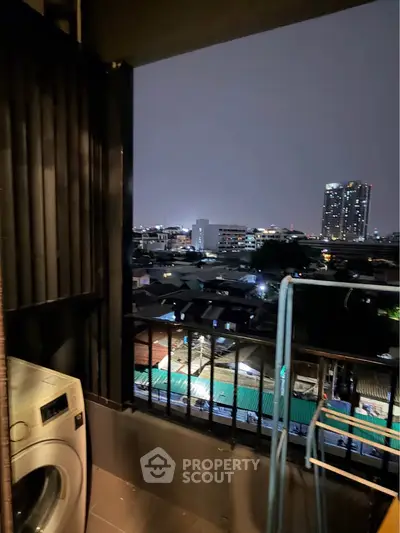 Urban balcony view with washing machine and city skyline at night