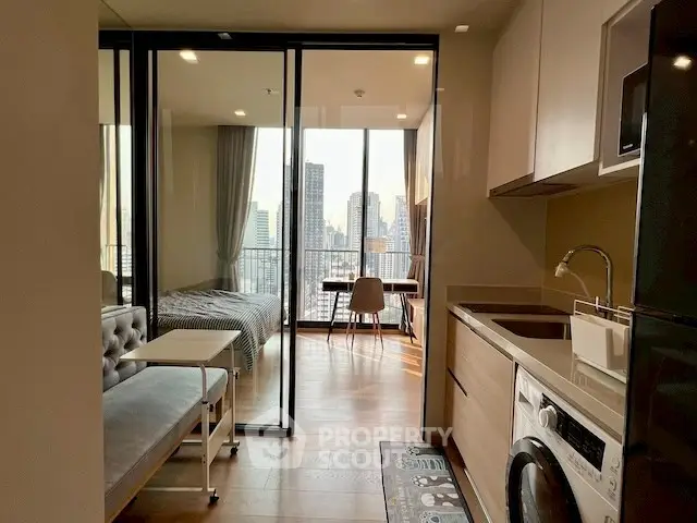 Modern apartment interior with open kitchen, cozy living area, and city view from the bedroom.