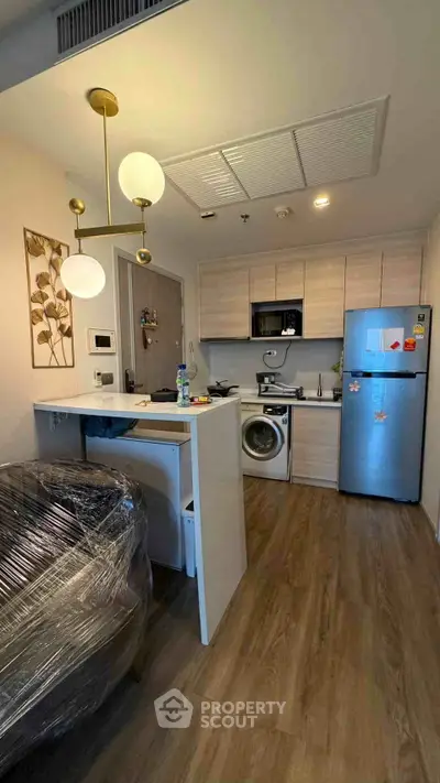 Modern kitchen with washing machine and fridge in compact apartment