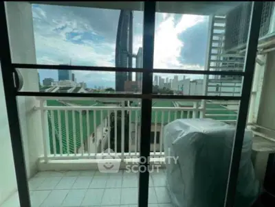 City view from a small balcony with glass doors and urban skyline.