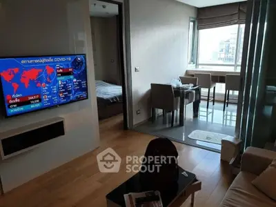 Modern apartment with open living area and city view, featuring sleek furniture and wooden flooring.