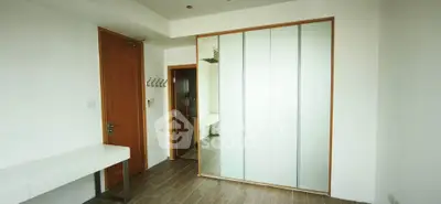 Spacious modern bedroom with wooden flooring and built-in wardrobe