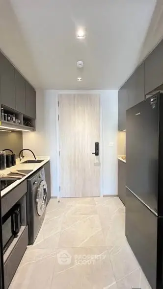 Modern kitchen with sleek appliances and ample storage in a stylish apartment.