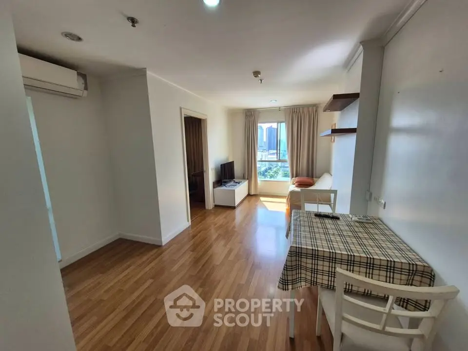 Bright and airy living room with wooden flooring and city view, perfect for modern urban living.