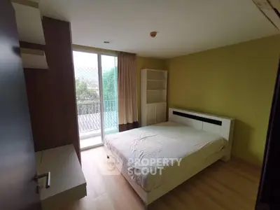 Spacious bedroom with balcony access and modern furnishings