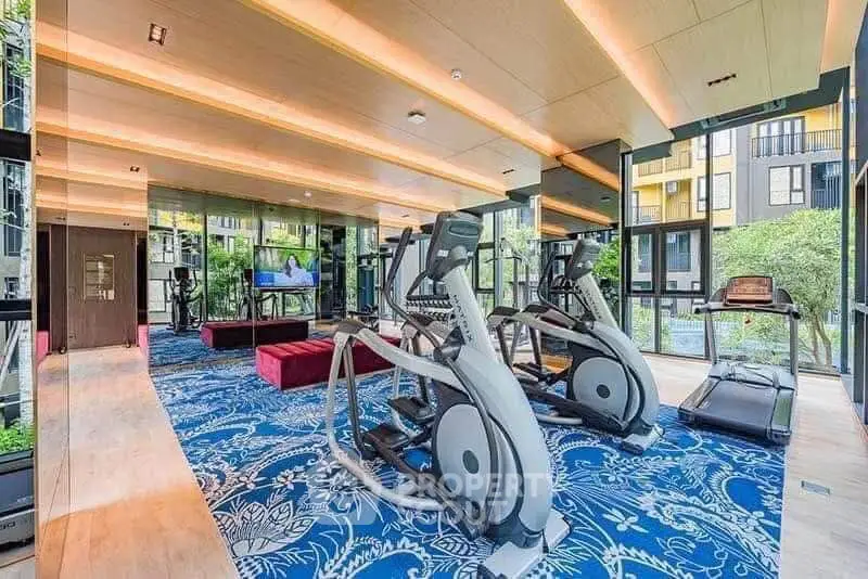 Luxurious gym with modern equipment and scenic garden views in upscale residential building.