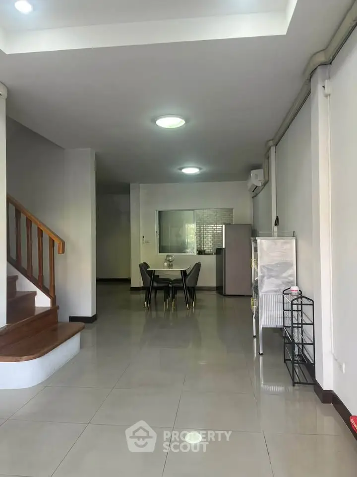 Spacious open-plan living area with modern dining set and staircase