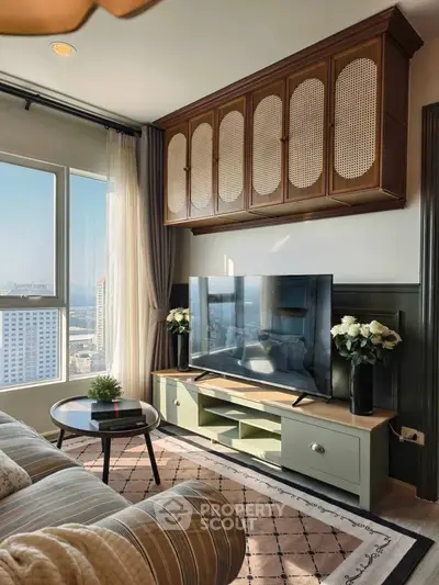 Stylish living room with large window, modern TV setup, and elegant decor in high-rise apartment.