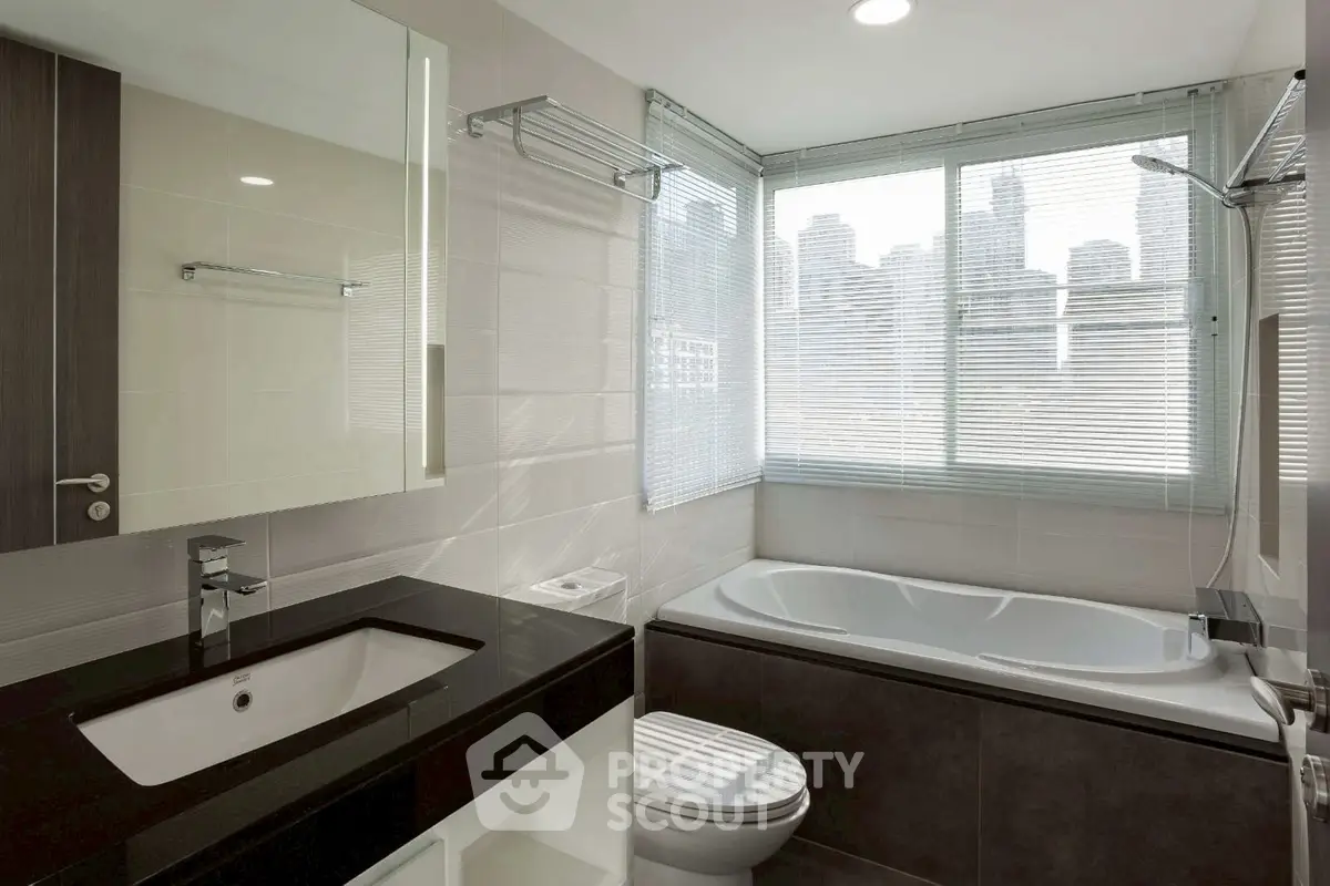 Modern bathroom with city view, featuring sleek fixtures and a bathtub.