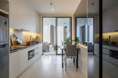 Modern open kitchen with dining area and living room view, sleek design and natural light.
