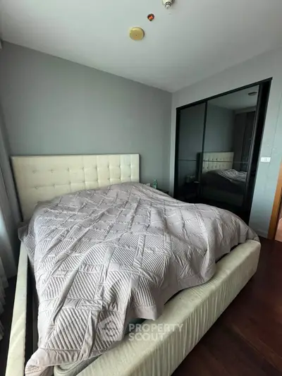 Cozy bedroom with modern design and mirrored closet doors, perfect for restful nights.