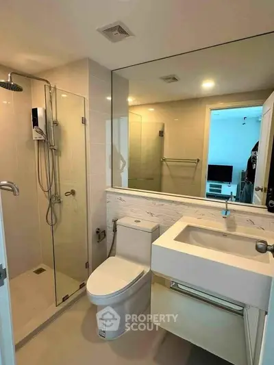 Modern bathroom with glass shower and sleek fixtures in a contemporary apartment.