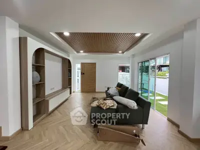 Spacious modern living room with stylish ceiling and large sliding doors to garden