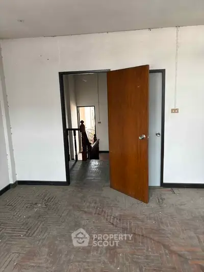 Spacious interior with open door leading to staircase, showcasing potential for renovation.