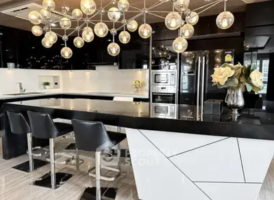 Luxurious modern kitchen with sleek black and white design, featuring stylish lighting and high-end appliances.