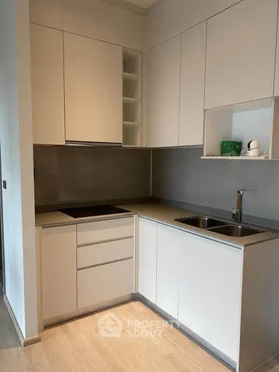 Modern kitchen with sleek cabinetry and integrated appliances in a stylish apartment.