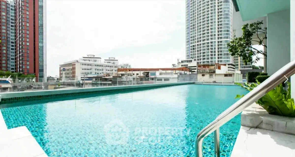 Luxurious rooftop pool with stunning cityscape views in modern high-rise building.