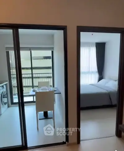 Modern apartment with open layout, featuring a cozy bedroom and a balcony with a washing machine.