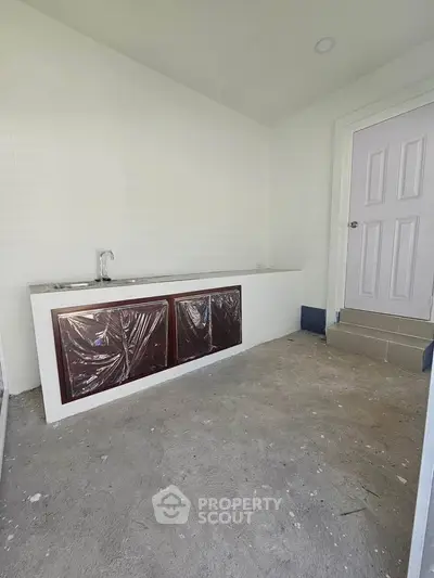 Minimalist kitchen space with basic cabinetry and sink, ideal for customization.