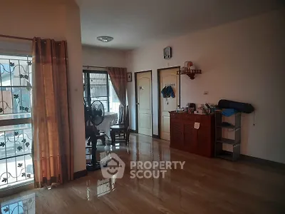 Spacious living room with polished wooden floors and natural light