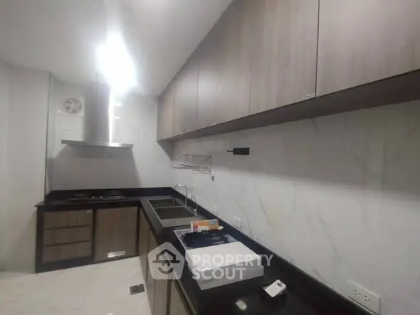 Modern kitchen with sleek cabinetry and marble backsplash in a contemporary apartment.