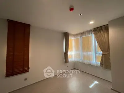 Spacious empty room with large windows and elegant curtains, perfect for customization.