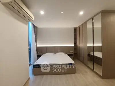 Modern bedroom with sleek design, mirrored wardrobe, and ambient lighting for a cozy atmosphere.
