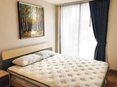Spacious bedroom with large window and elegant decor in modern apartment.