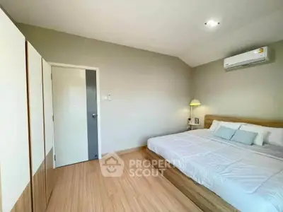 Spacious bedroom with modern design and natural light, featuring a comfortable bed and stylish decor.