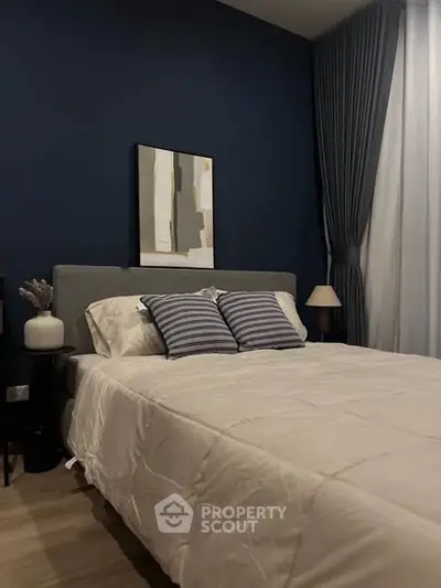 Cozy bedroom with modern decor and elegant blue accent wall