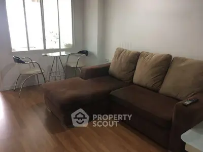 Cozy living room with brown sectional sofa and modern dining set by the window.