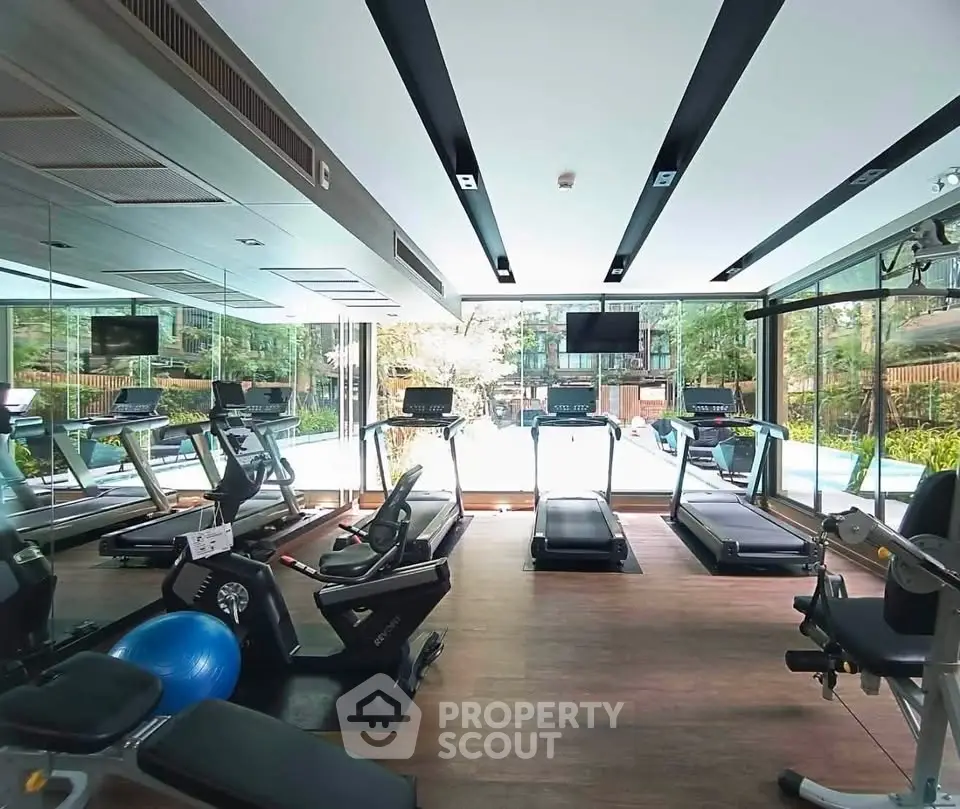 Modern gym with state-of-the-art equipment and scenic outdoor view, perfect for fitness enthusiasts.