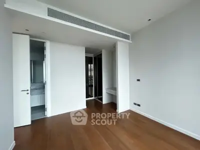 Spacious empty bedroom with wooden flooring and modern design