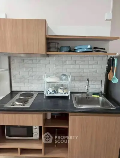 Modern kitchen with sleek cabinetry, electric stove, and stylish backsplash, perfect for urban living.