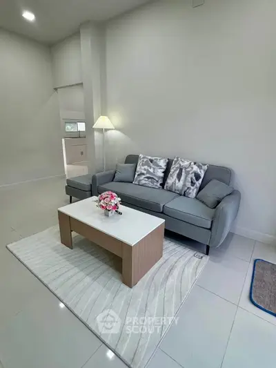 Modern living room with stylish gray sofa and elegant coffee table on a chic rug.