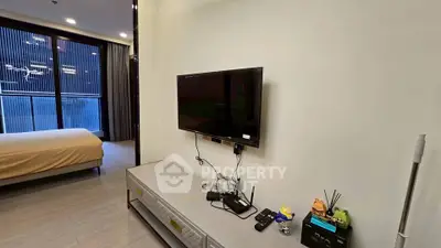 Modern living room with wall-mounted TV and sleek furniture in a stylish apartment.