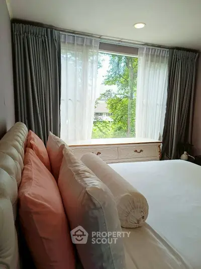 Cozy bedroom with large window and lush green view
