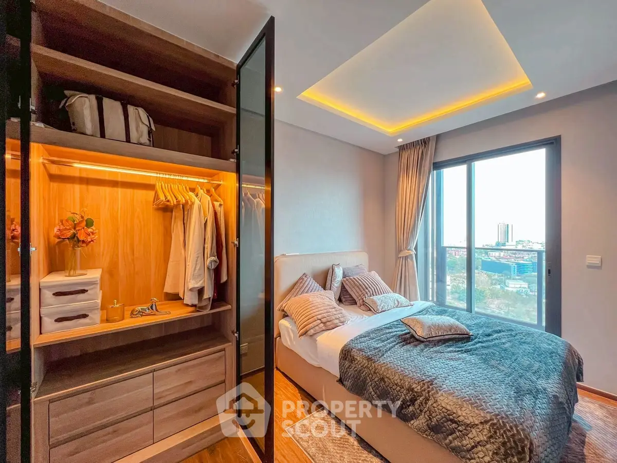 Luxurious bedroom with city view, featuring a stylish wardrobe and elegant decor.