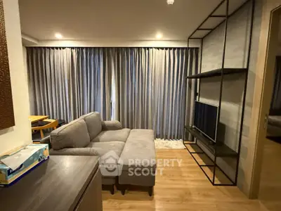 Modern living room with cozy gray sofa and stylish shelving unit, perfect for relaxation and entertainment.