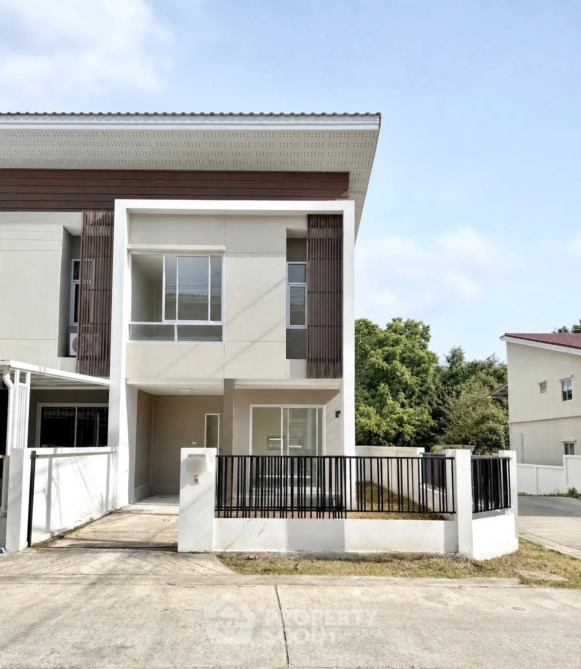 Modern two-story house with sleek design and spacious driveway in a serene neighborhood.