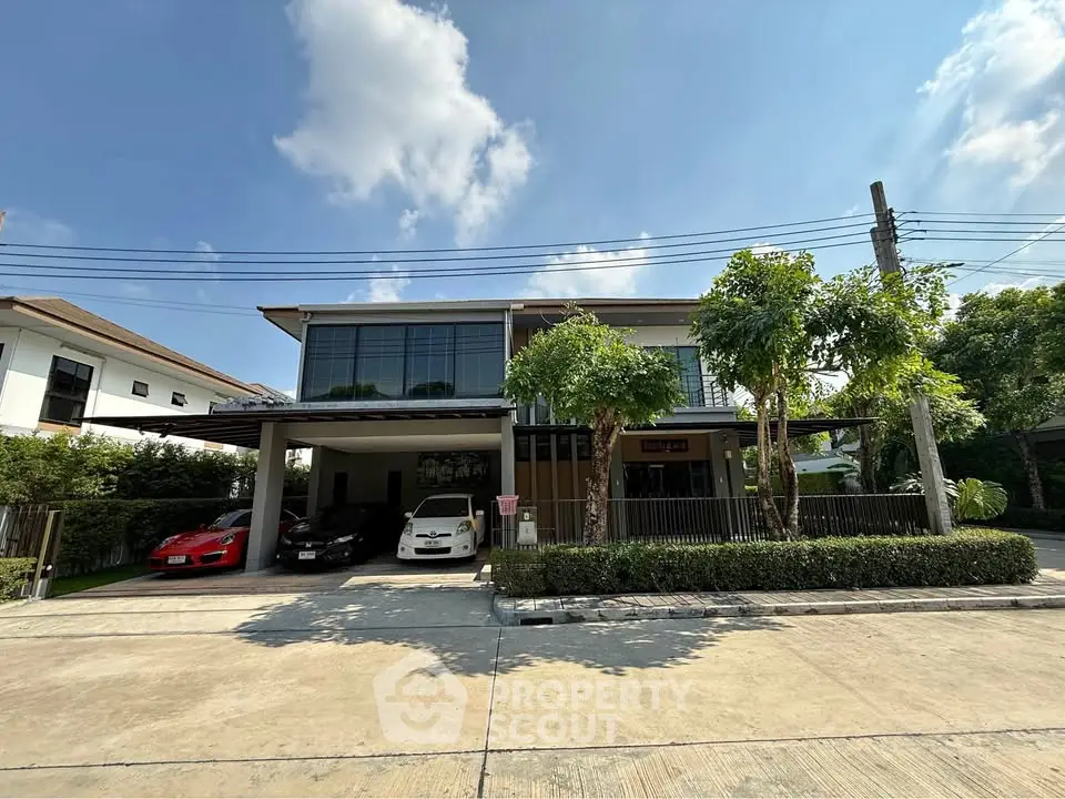 Modern two-story house with spacious driveway and lush greenery in a serene neighborhood.