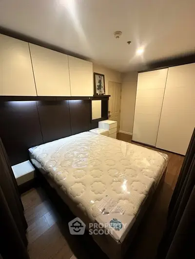 Modern bedroom with sleek design, featuring a comfortable bed and ample storage space.