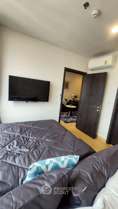 Modern bedroom with TV and air conditioning, connecting to stylish living room.