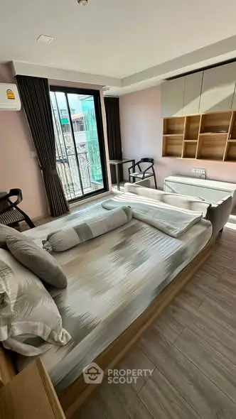 Modern bedroom with large window and stylish furnishings in urban apartment